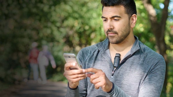 Man using mobile phone while wearing BodyGuardian