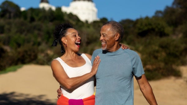 Happy older couple walking on the beach
