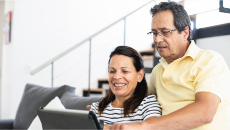 Middle-aged couple using a touchscreen tablet
