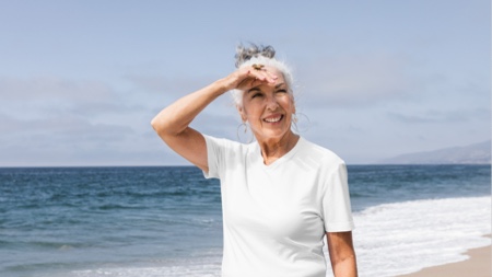 Older woman smiling while walking on the beach