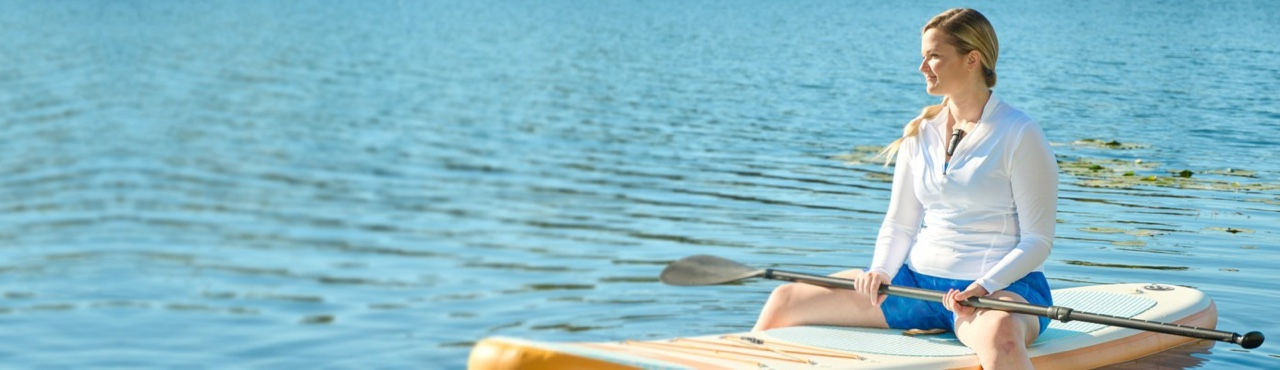 Hero banner showing smiling younger woman on paddleboard with BodyGuardian