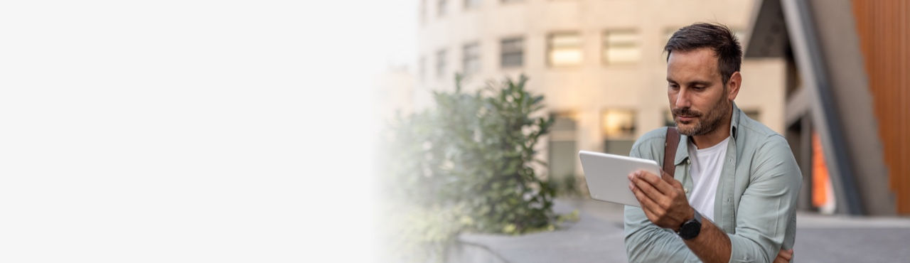 Hero banner showing middle-aged man outside of buidling with touchscreen tablet